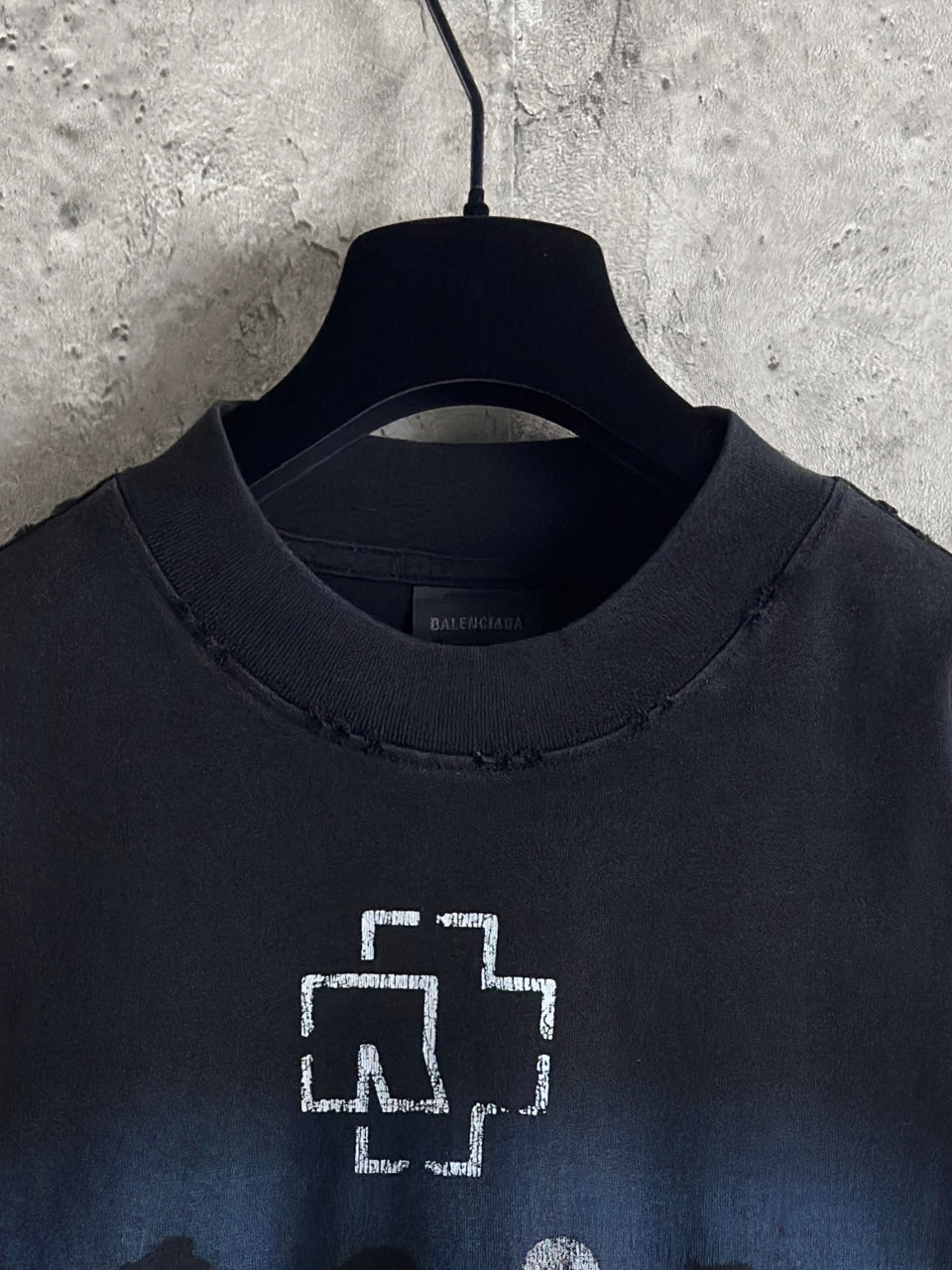 Black crewneck T-shirt neckline with white graphic cross and small text print