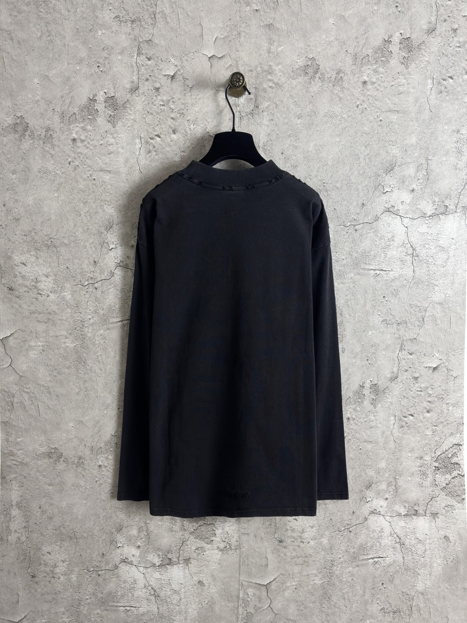 Black long-sleeve crewneck T-shirt, plain back view, hanging on a hanger