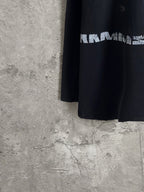 Black long-sleeve T-shirt side view with partial white graphic lettering