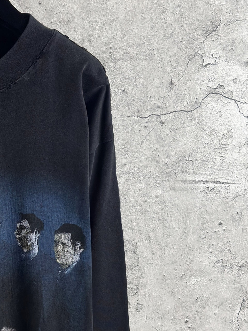 Black long-sleeve T-shirt sleeve area with faded figure print in gray