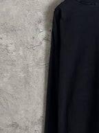 Black long-sleeve T-shirt back side view, plain fabric with minimal seam lines