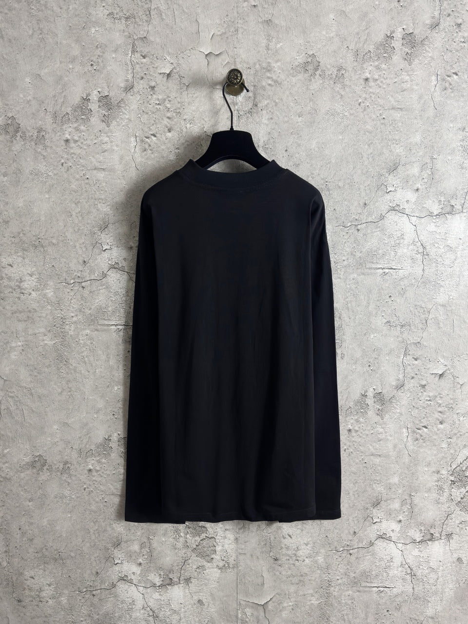 Long-sleeve crewneck shirt with dark back view on hanging display