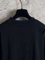 Black long-sleeve T-shirt neckline and shoulder view on hanger