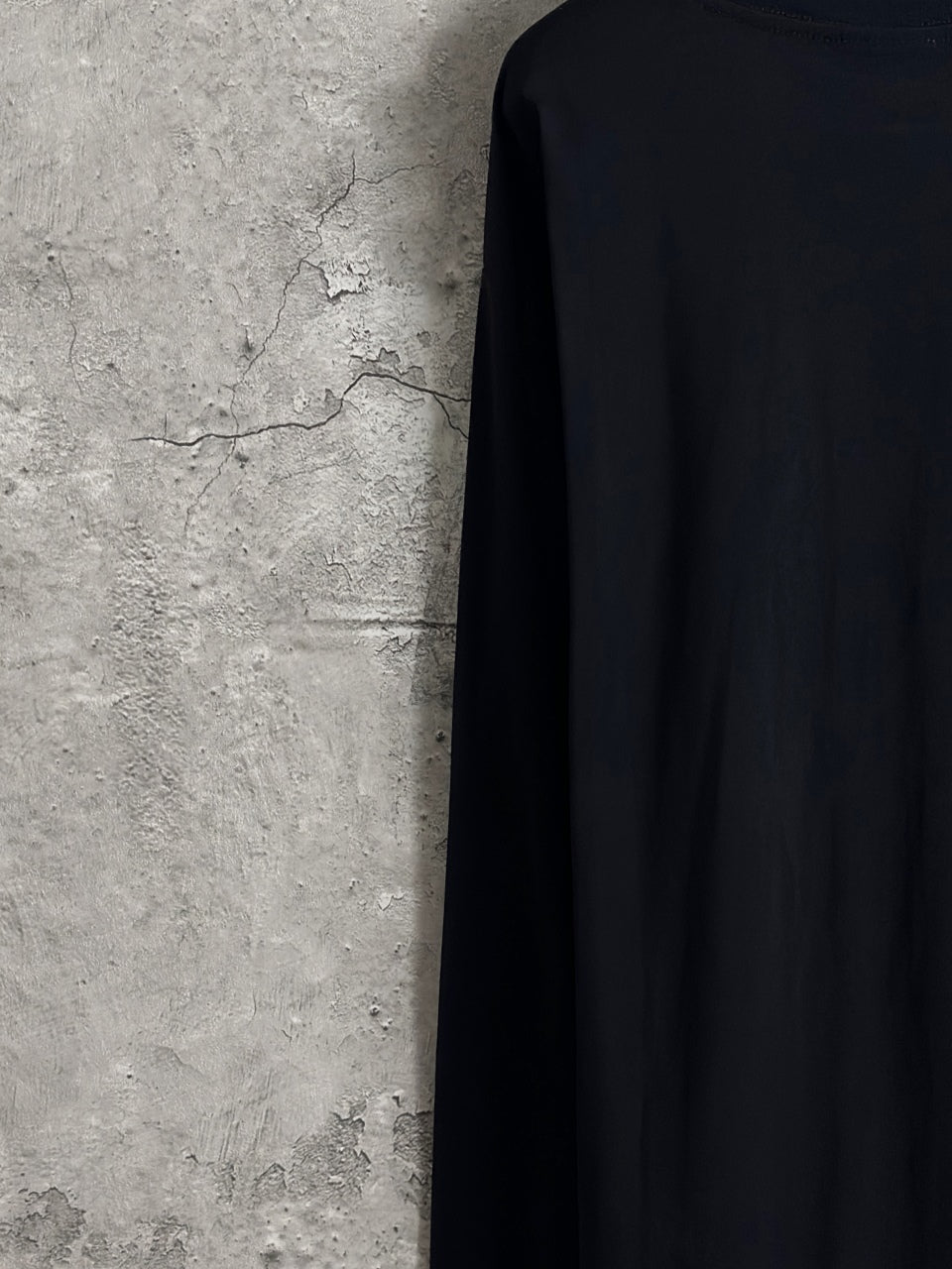 Long-sleeve crewneck shirt side-back view with dark fabric and flat seams