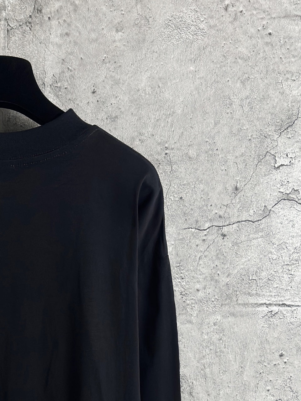 Long-sleeve crewneck shirt shoulder and upper back close-up in dark fabric