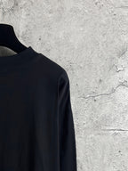 Black long-sleeve T-shirt side view with smooth fabric and hem