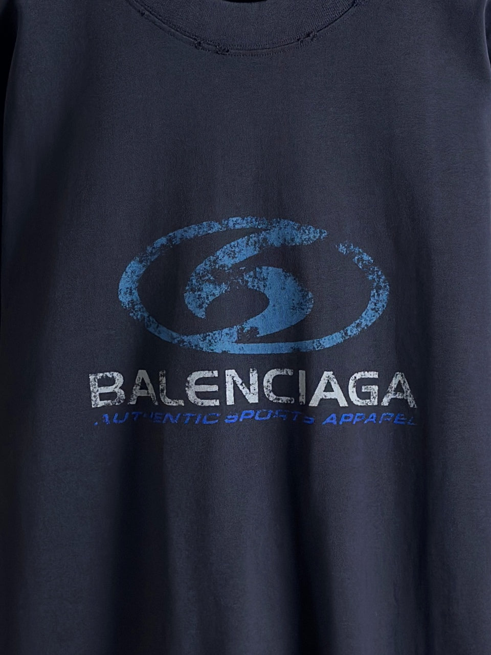 Balenciaga dark blue crewneck top with oval logo and small tagline beneath