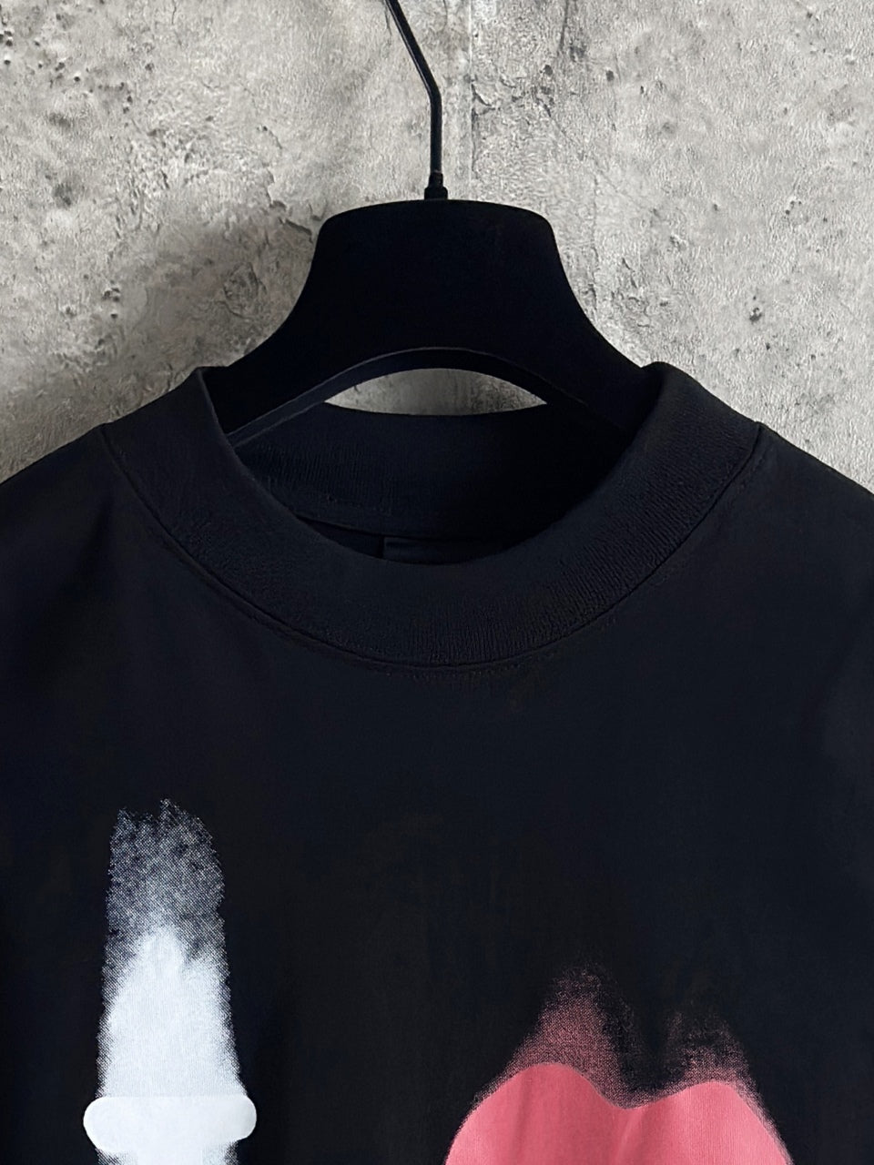Balenciaga long-sleeve top neckline close-up with candle graphic and dark fabric