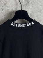 Balenciaga long-sleeve top back neckline close-up with BALENCIAGA lettering