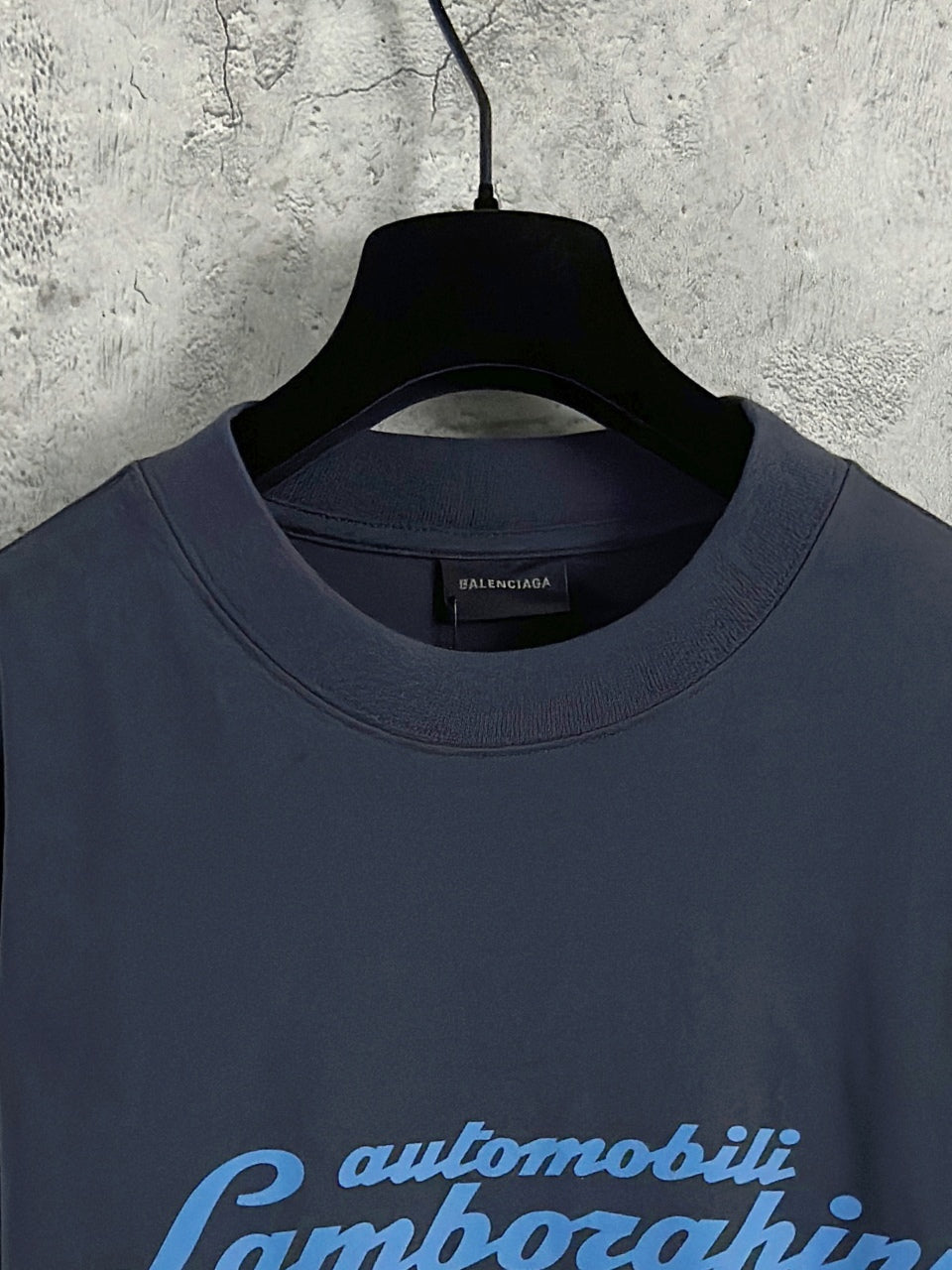 Dark blue crewneck long-sleeve T-shirt neckline with small Balenciaga logo tag.