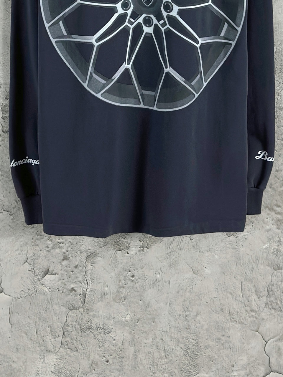 Dark blue long-sleeve T-shirt back view with large white wheel graphic near top.