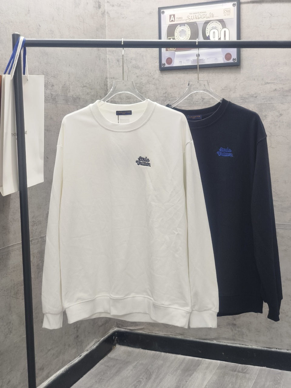 White long-sleeve crewneck sweatshirt with small blue chest logo