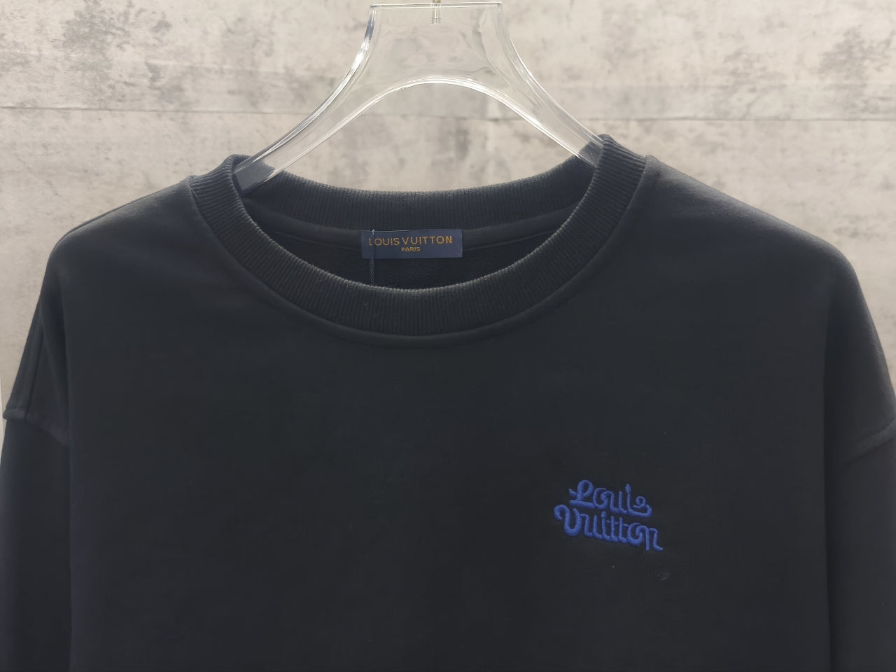 Dark long-sleeve crewneck sweatshirt with small blue front logo