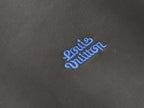 Close-up of embroidered blue logo on dark sweatshirt fabric