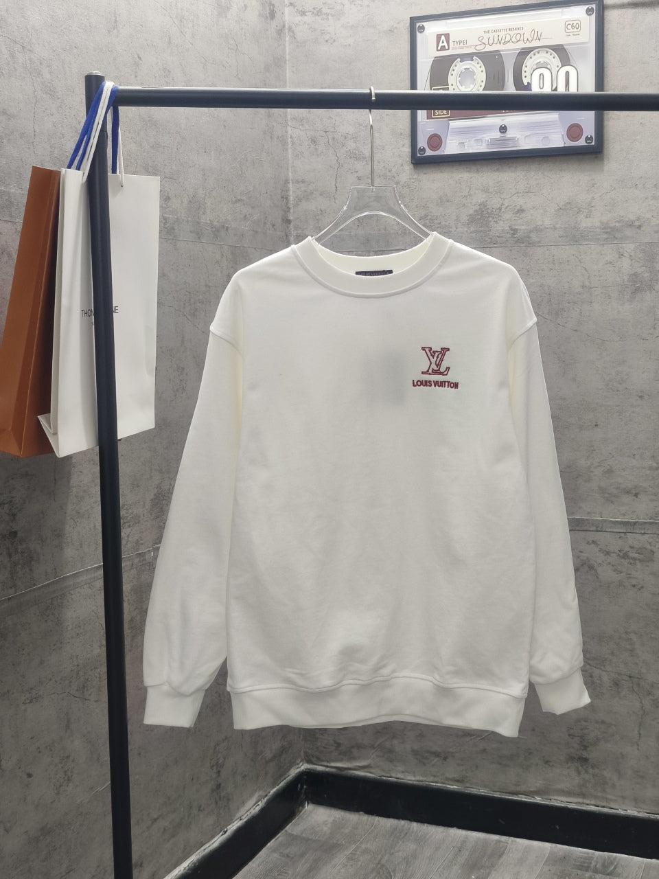 White long-sleeve sweatshirt with red Louis Vuitton logo on the chest