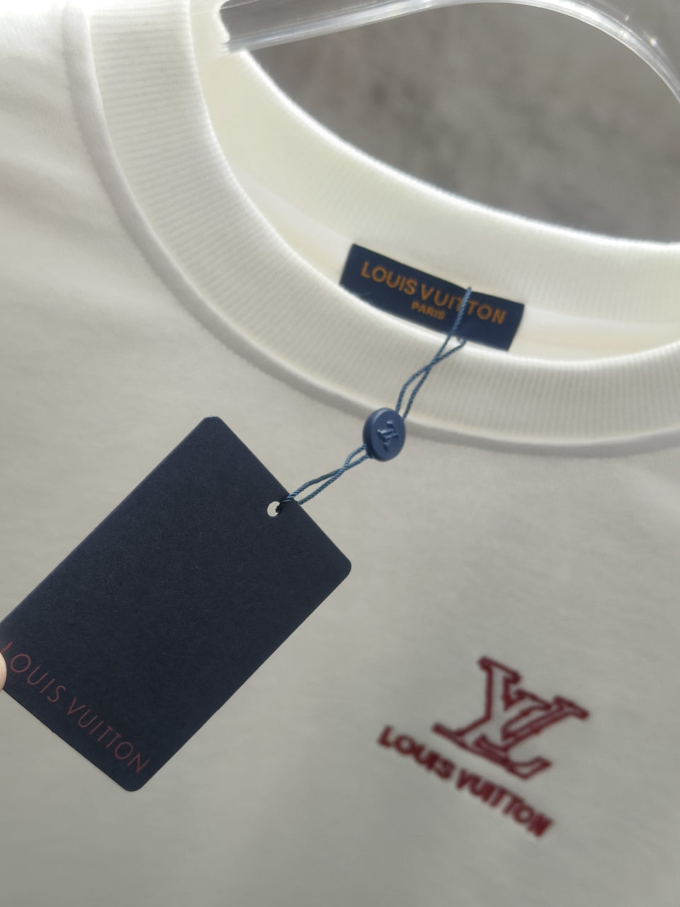 White long-sleeve sweatshirt with neck label and hanging price tag