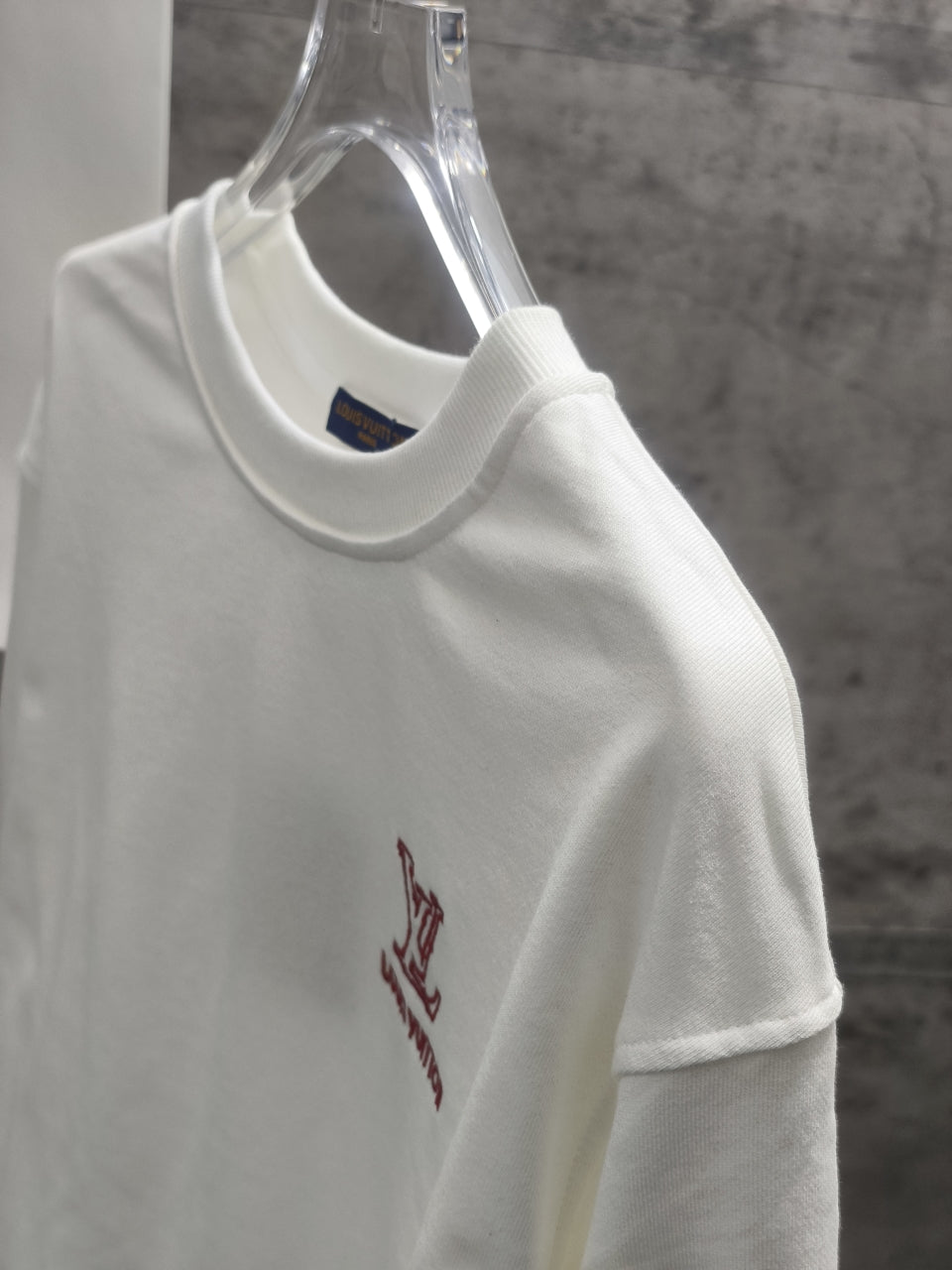 White short-sleeve sweatshirt with small red Louis Vuitton logo on chest