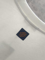 White sweatshirt with ribbed collar and dark navy brand label