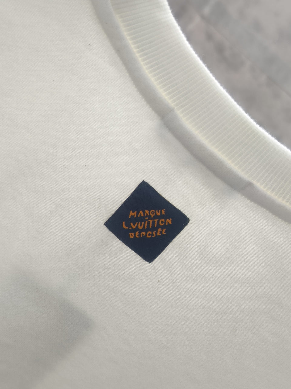White sweatshirt with ribbed collar and dark navy brand label