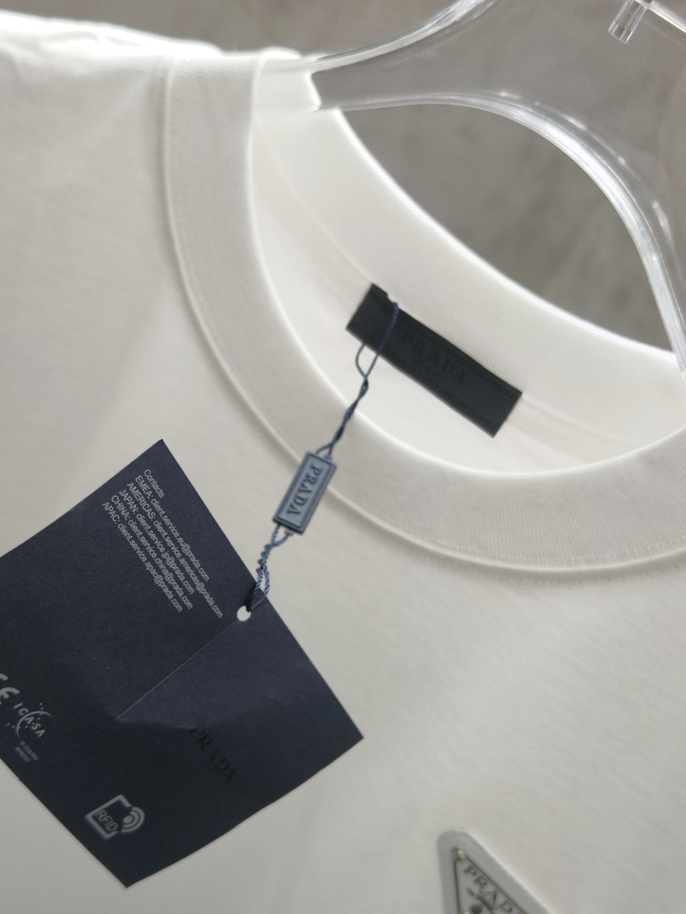 White crew-neck T-shirt with attached hang tags and woven neck label