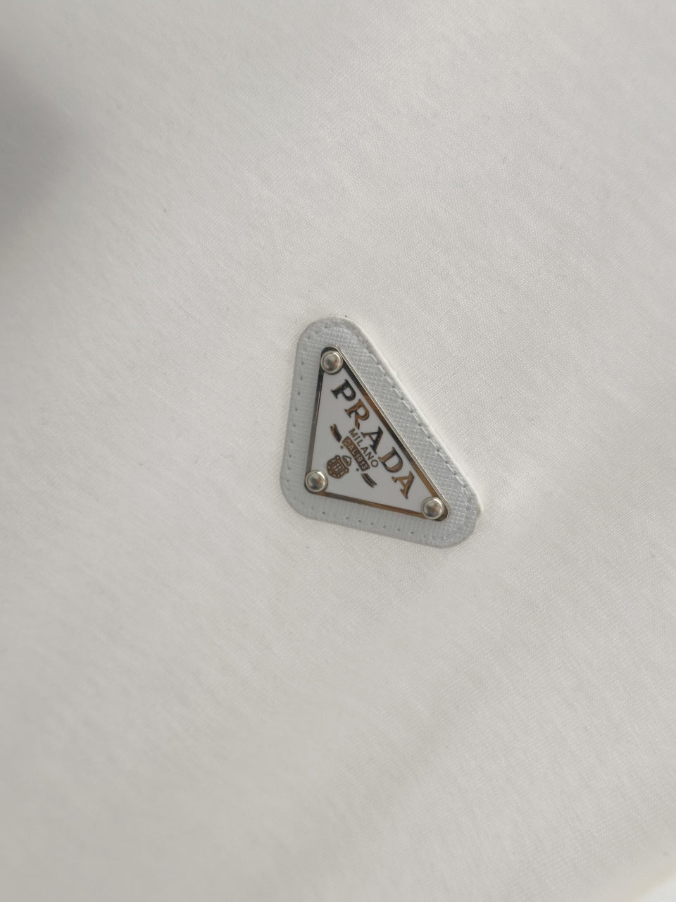 White T-shirt with silver-toned triangular PRADA logo patch