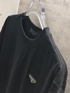 Dark short-sleeve T-shirt with logo patch on chest, side view