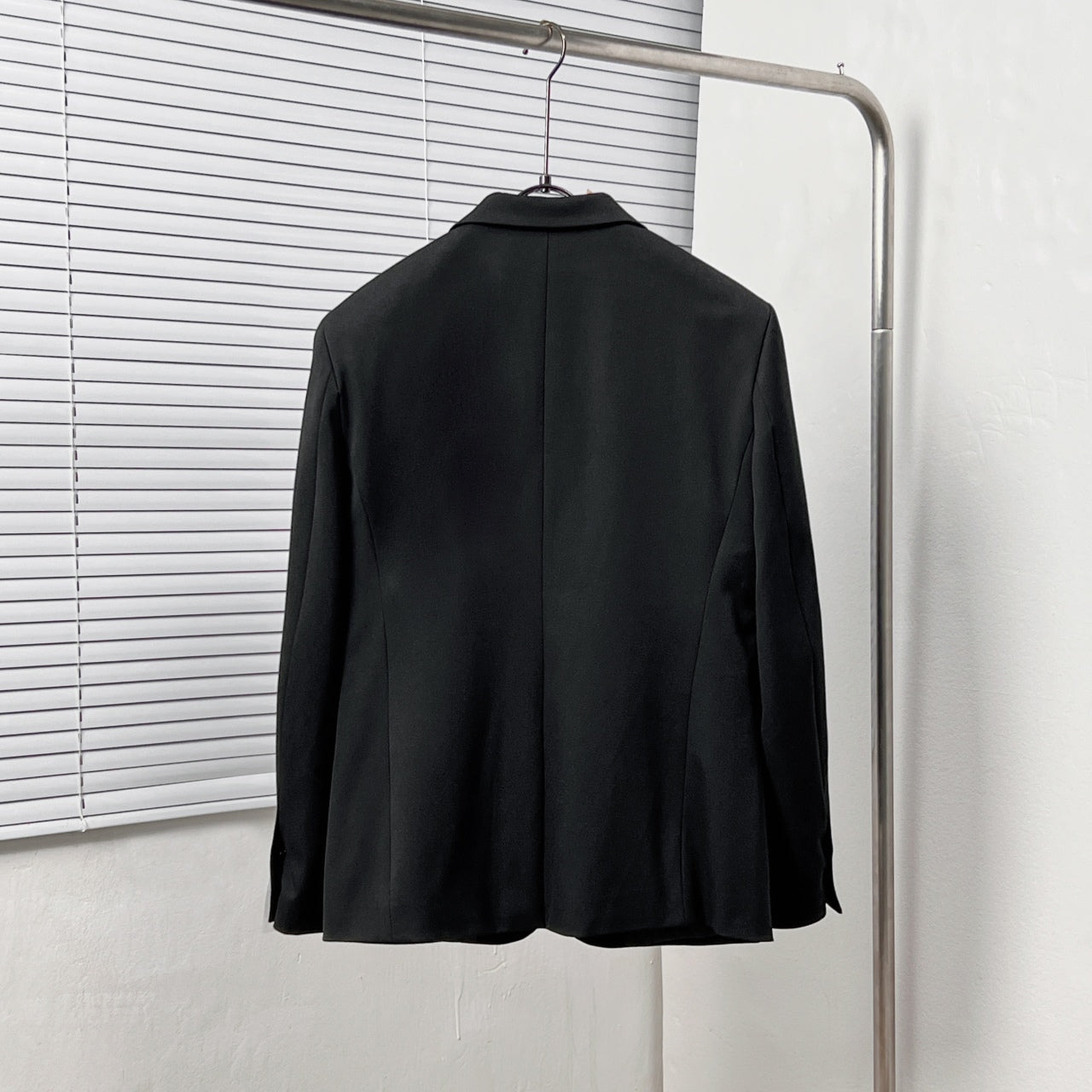 Black Dior suit jacket from the back, centered with shoulder seams and smooth hem