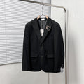 Black Dior suit jacket with notched lapels and two front flap pockets