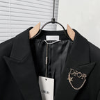 Black Dior suit jacket with buttoned front, star chain pin detail, and hanging tag