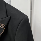 Black suit jacket shoulder and lapel with structured seam and clean edge styling