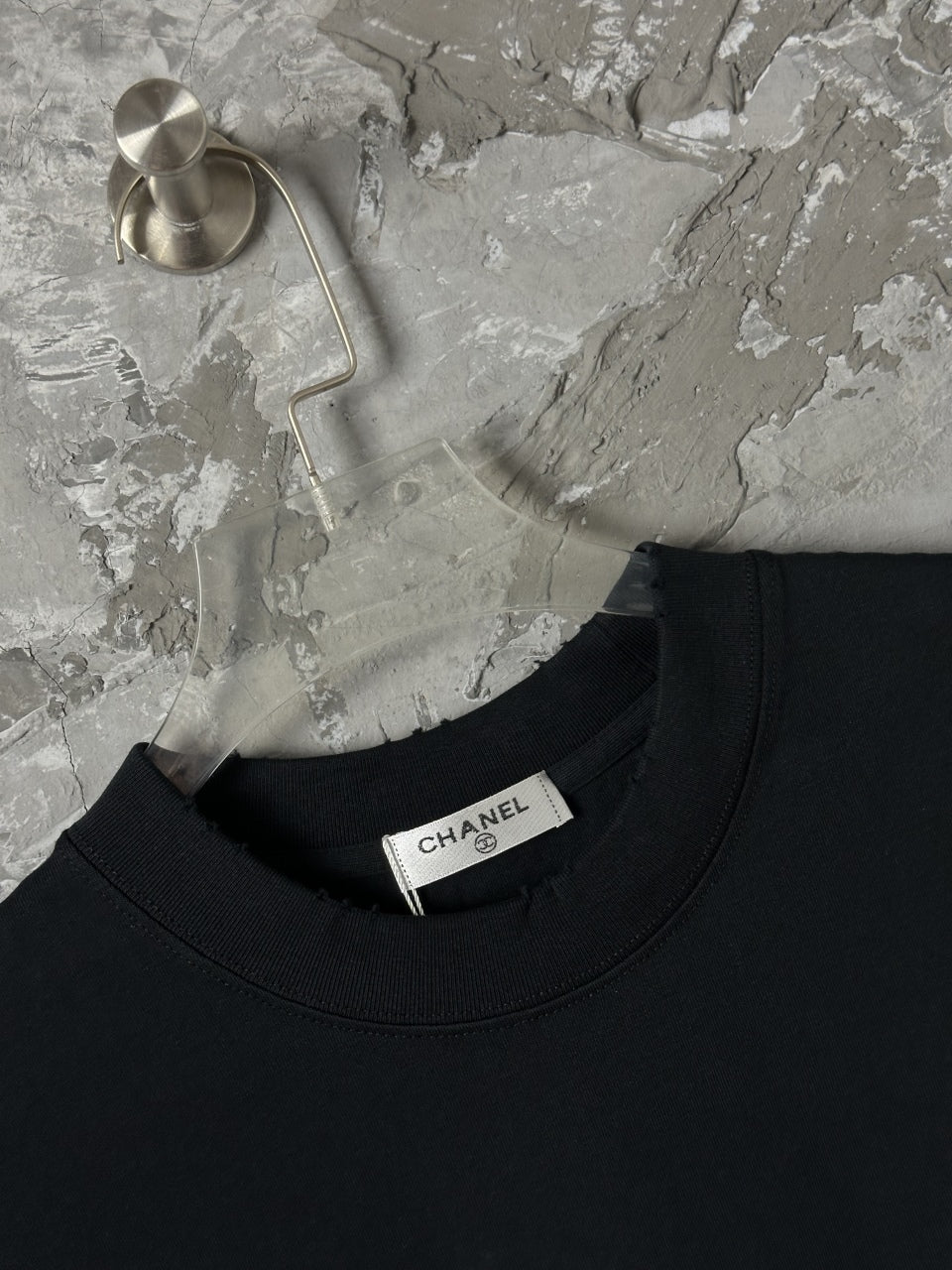 Black crew-neck T-shirt with CHANEL label at collar
