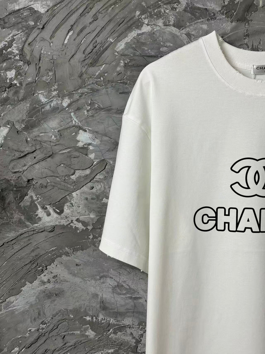 White short-sleeve T-shirt with partial CHANEL graphic on chest