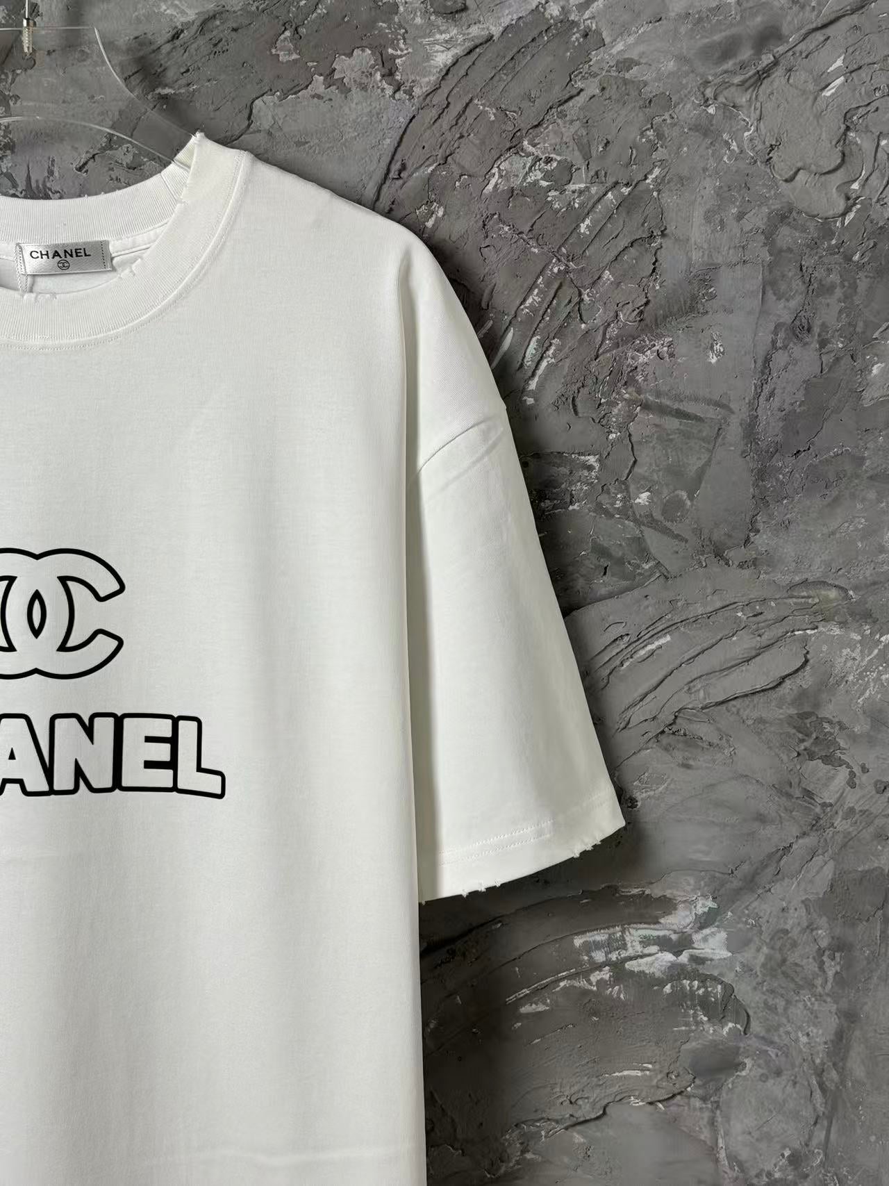 White short-sleeve T-shirt with CHANEL logo print on left chest