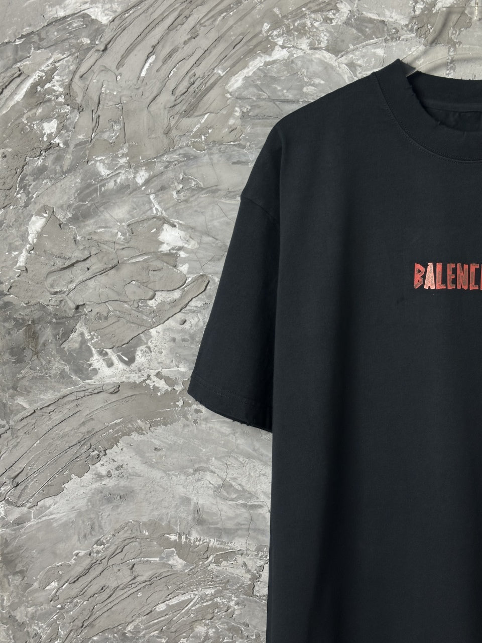 Black short-sleeve T-shirt with partial red BALENCIAGA logo at chest
