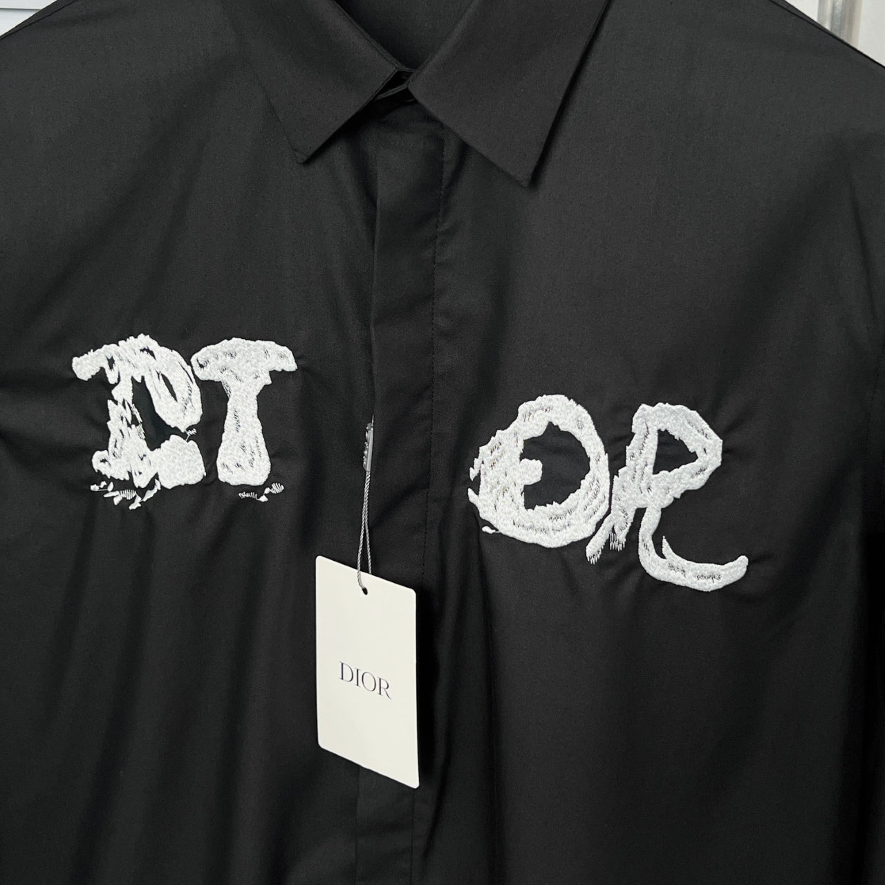 Dior long-sleeve shirt front with embroidered white letters and brand tag