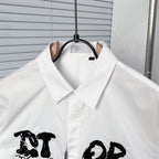 White button-up dress shirt collar with black graphic logo detail