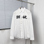 White button-up dress shirt with black graphic logo on chest