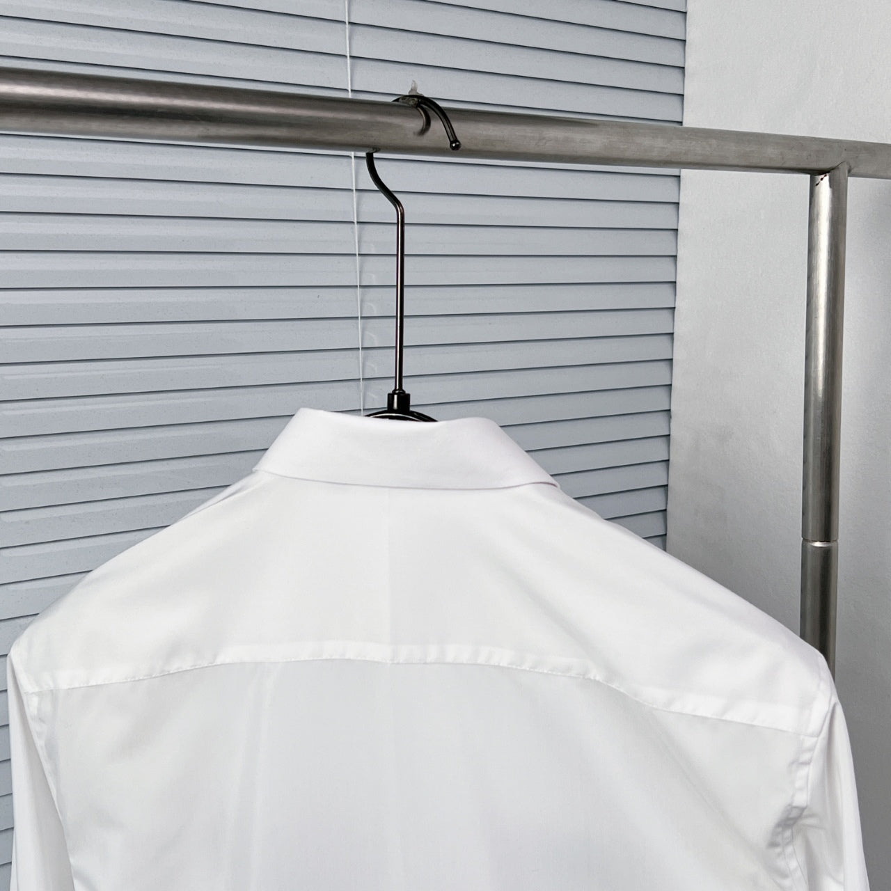 White button-up dress shirt back view on hanger