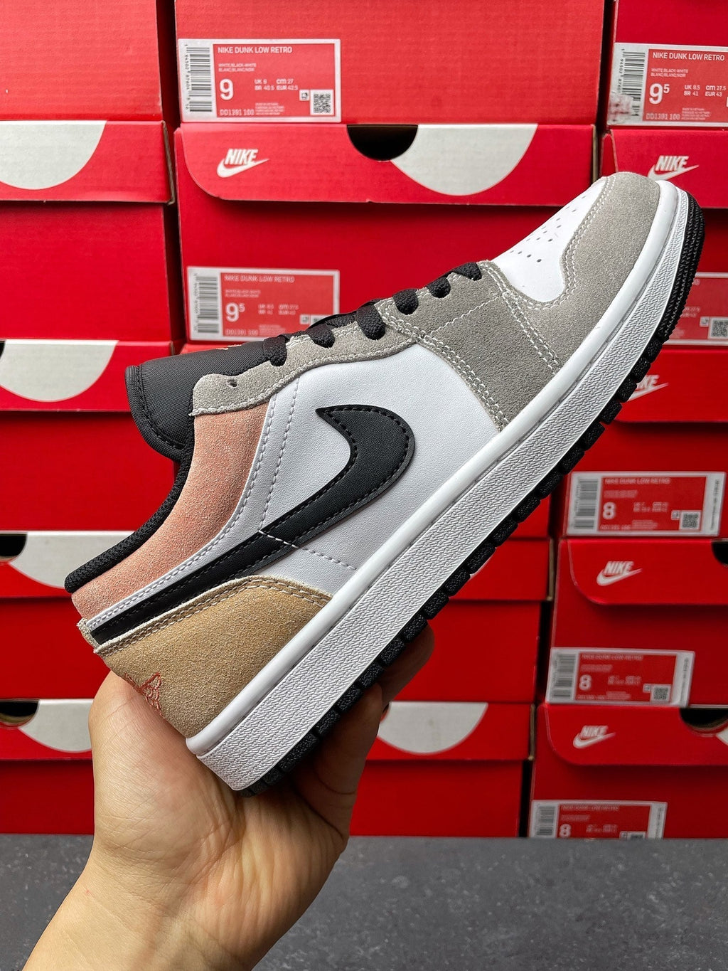 Low-top sneakers, side view in gray, white, tan suede and black swoosh