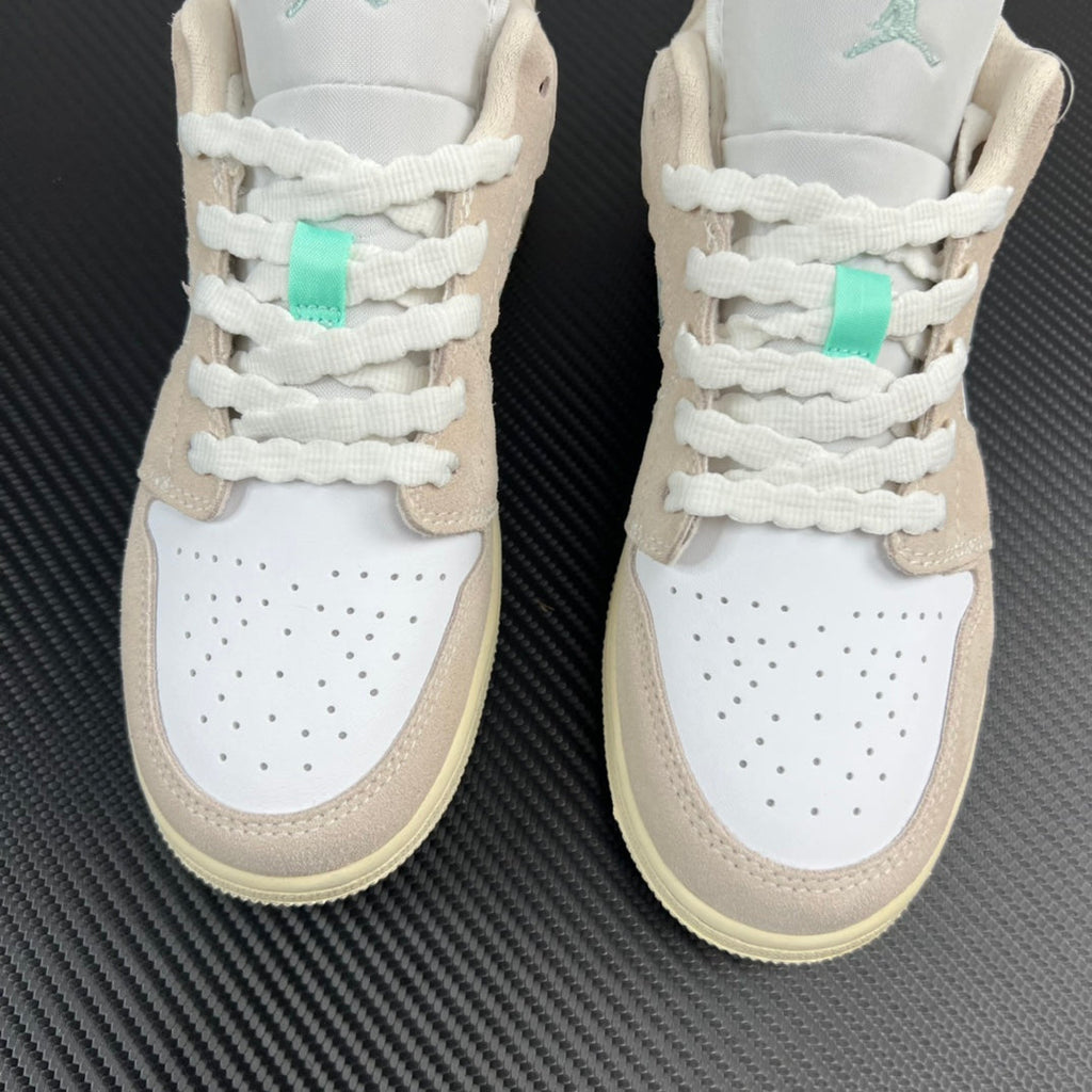 Air Jordan 1 Low front pair, white leather with tan overlays and mint lace tabs.