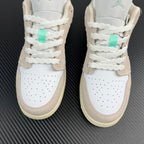 Air Jordan 1 Low front pair, white leather with tan overlays and mint lace tabs.