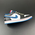 Low-top sneaker with white, black, and blue panels, cream laces, and red/blue sole