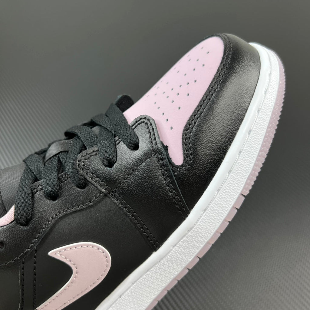 Air Jordan 1 Low sneakers close-up, black upper with pink swoosh detail