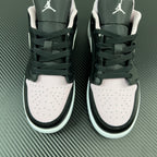 Air Jordan 1 Low sneakers pair, black and white uppers with Air logo on heels