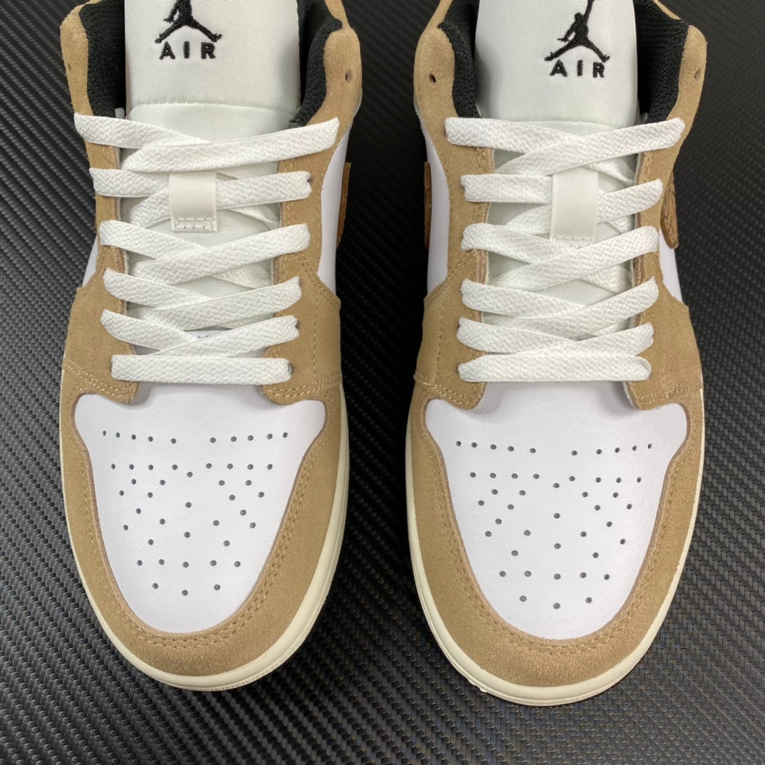 Pair of tan and white low-top sneakers with perforated toe and white laces