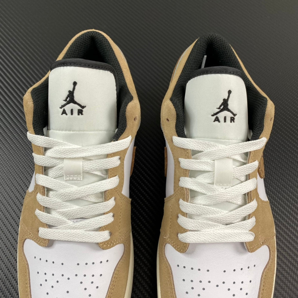 Pair of tan and white low-top sneakers with AIR logo on tongues and laces