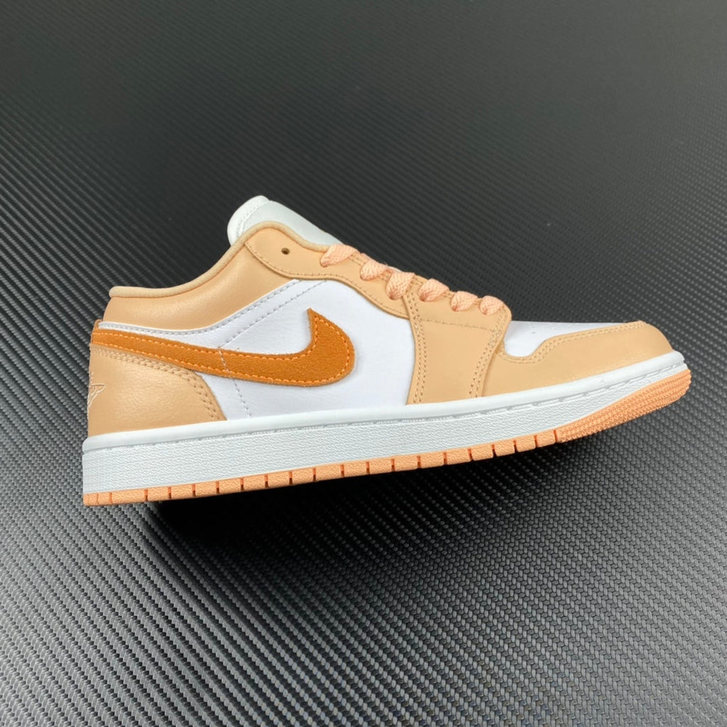 Air Jordan 1 Low sneakers with white, tan, and orange panels; orange lace eyelets