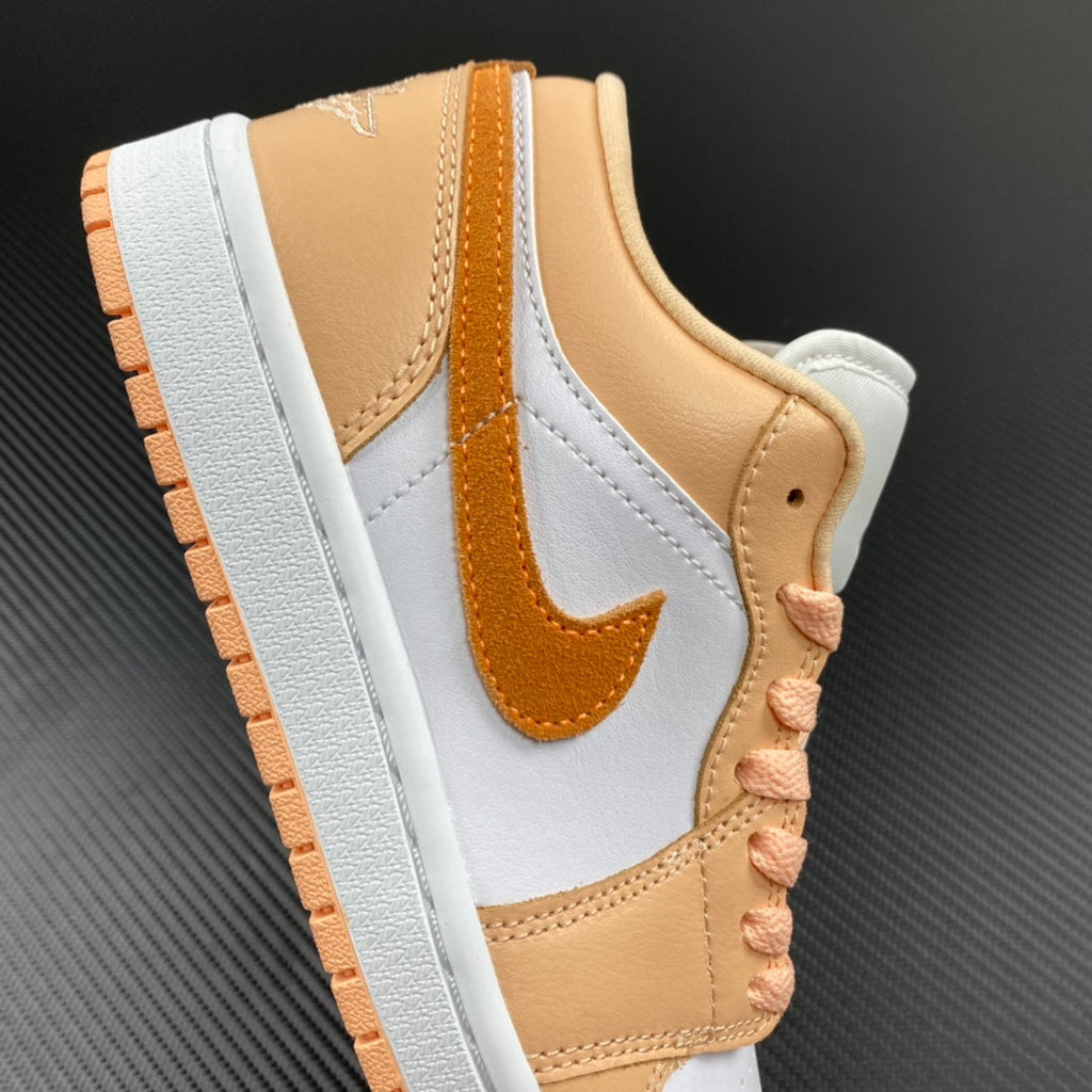 Air Jordan 1 Low sneakers side view with white overlays, tan heel, orange swoosh