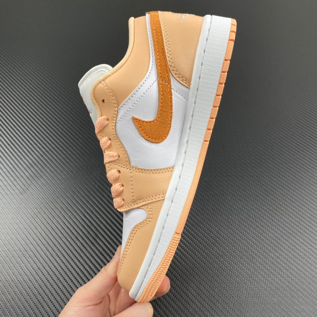 Air Jordan 1 Low sneakers with tan collar, white panels, and orange-trimmed sole