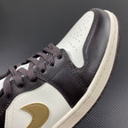 Low-top sneakers with dark brown leather upper, white side panel, and lace-up